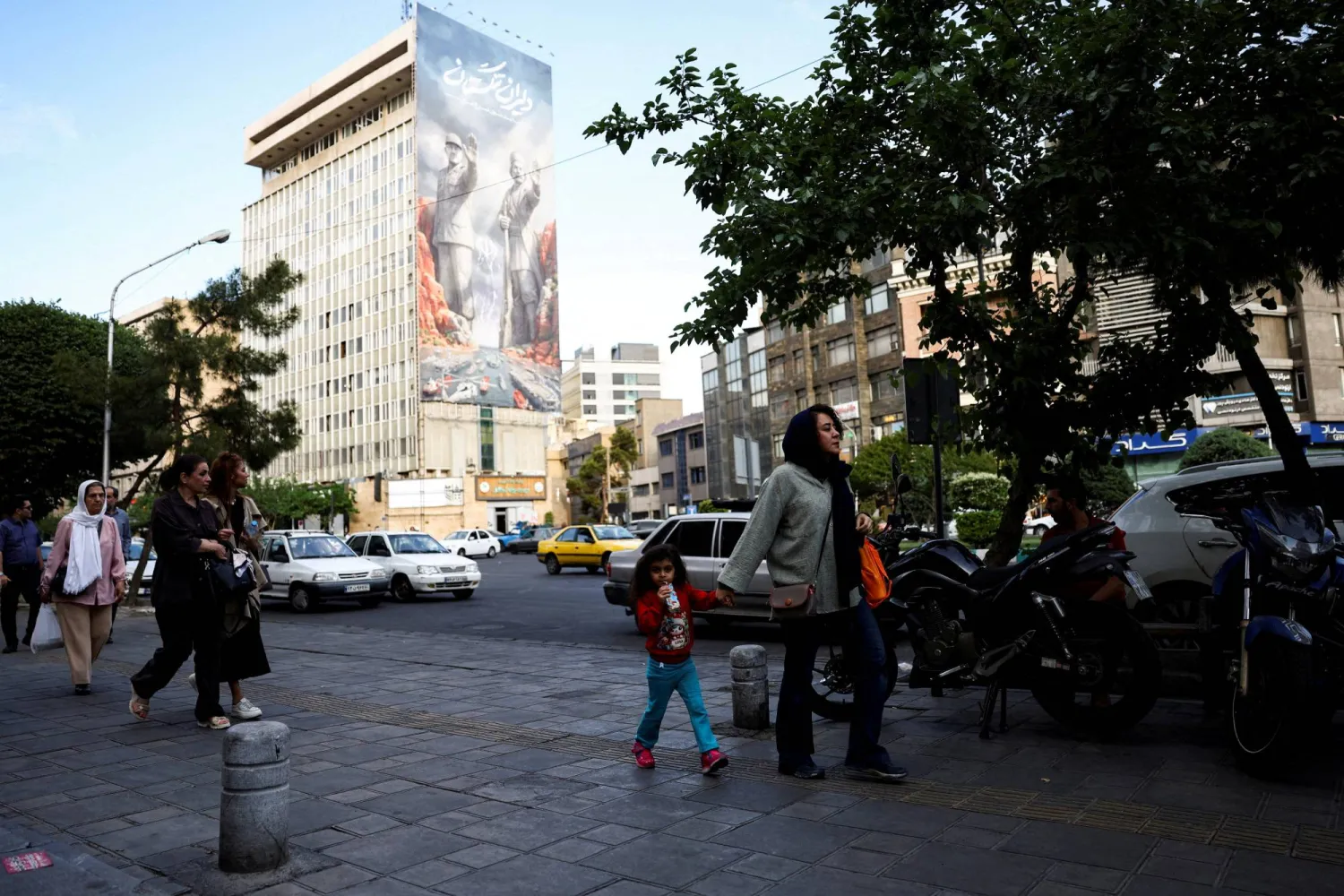 FILE PHOTO: People walk past a billboard about the Strait of Hormuz, in Tehran, Iran, May 17, 2026. Majid Asgaripour/WANA (West Asia News Agency) via REUTERS 