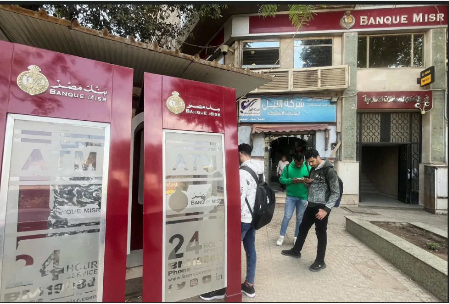 مواطنون مصريون أمام ماكينات الصرف التابعة لأحد البنوك الحكومية (رويترز)