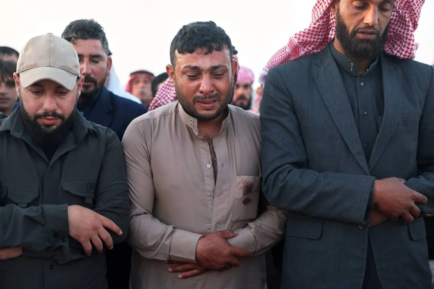 Idris Al-Ridah, center, weeps as he prays during the funeral of his son Mohammed, who was killed in an explosion caused by war remnants while playing with other children in the village of Abu Habbah in eastern Idlib countryside, in Abu Habbah, Syria, Thursday, May 21, 2026. (AP)