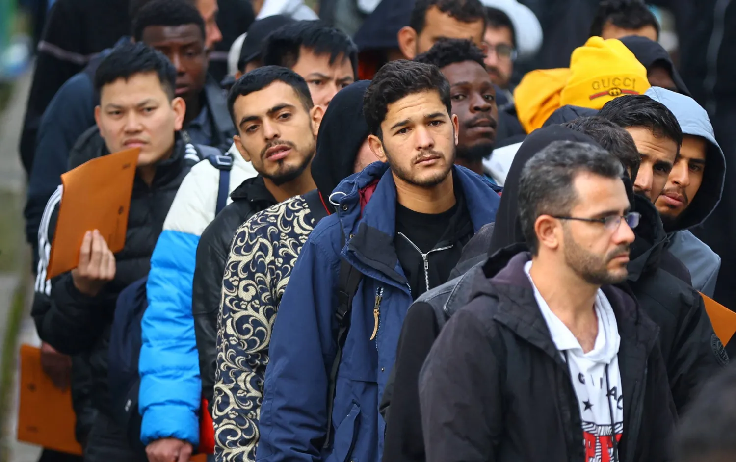 مهاجرون يصطفون أمام مركز استقبال طالبي لجوء في العاصمة الألمانية برلين (أرشيفية - رويترز)