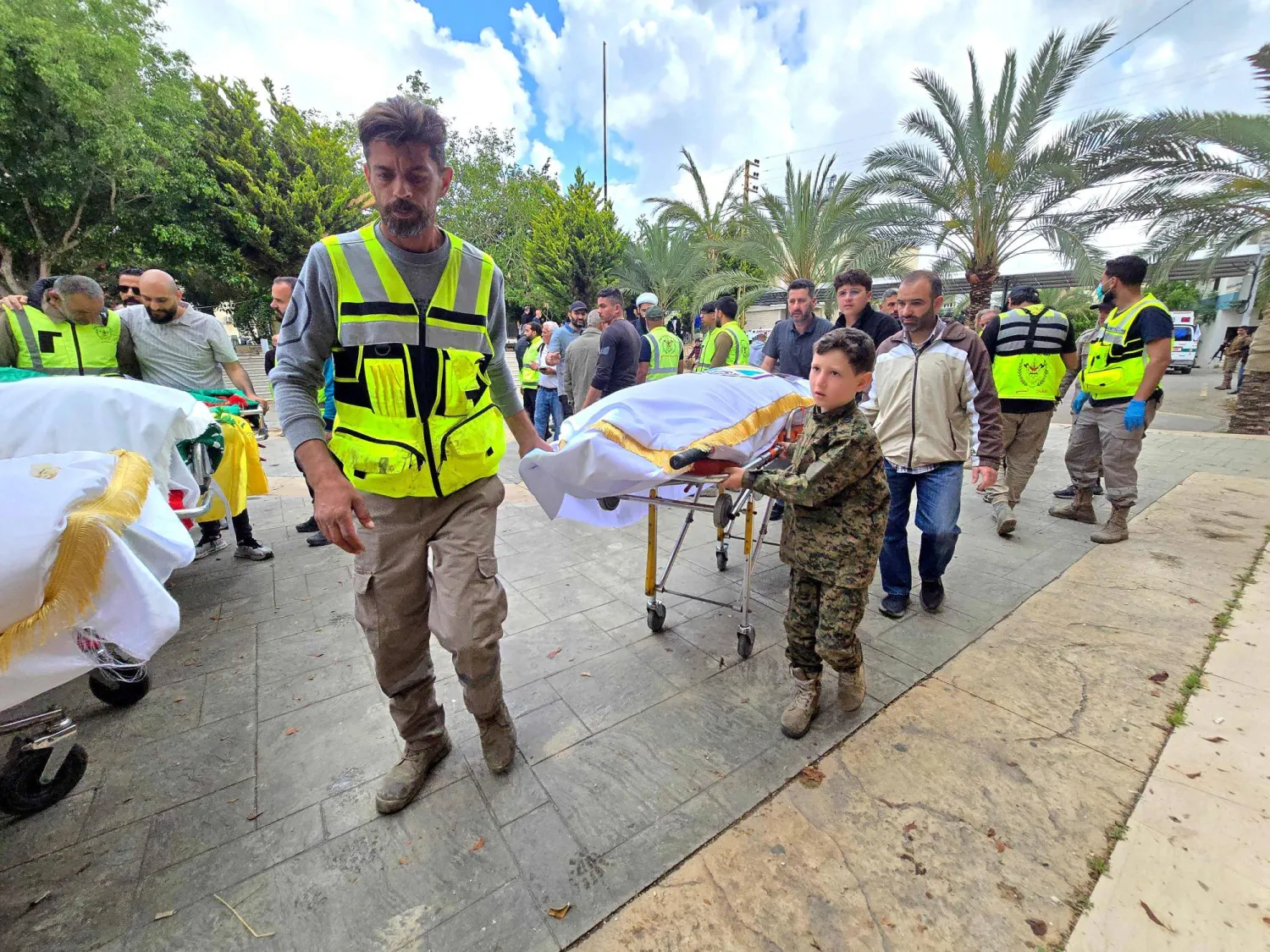 أشخاص يصلون برفقة جثامين ضحايا الغارة الإسرائيلية على قرية دير قانون النهر الجنوبية لبدء مراسم الدفن في منطقة صور بجنوب لبنان (أ.ف.ب)