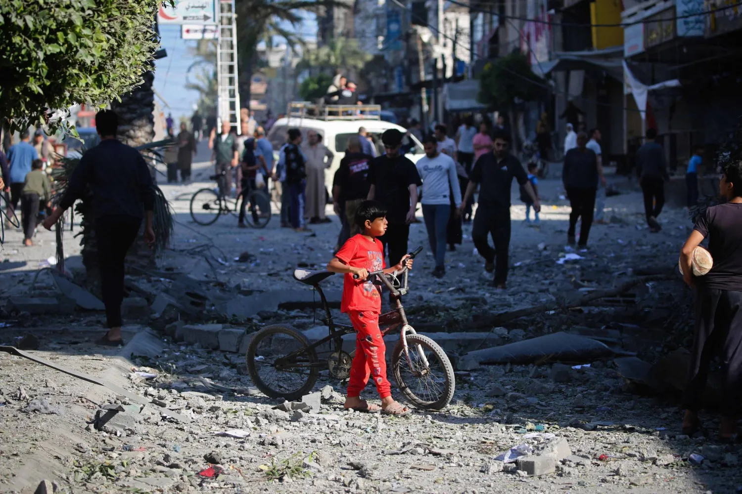 فتى فلسطيني يقف وسط حطام مبنى دمره قصف إسرائيلي في مخيم النصيرات بوسط قطاع غزة (أ.ف.ب)