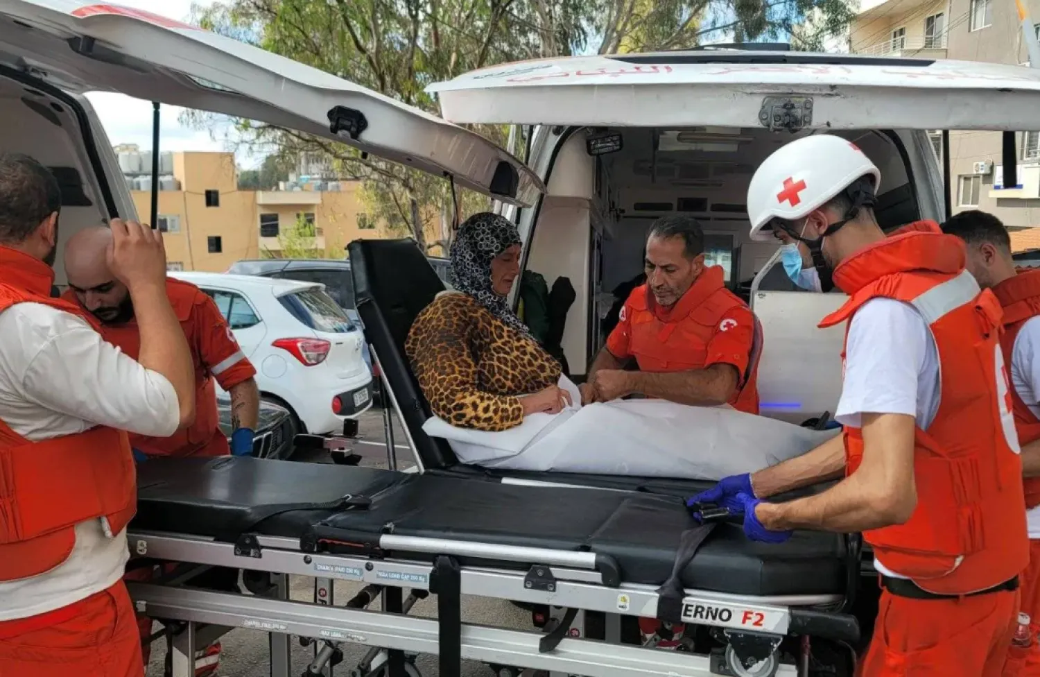 Volunteers from the Lebanese Red Cross rescue a woman in the city of Nabatieh in South Lebanon (AFP)
