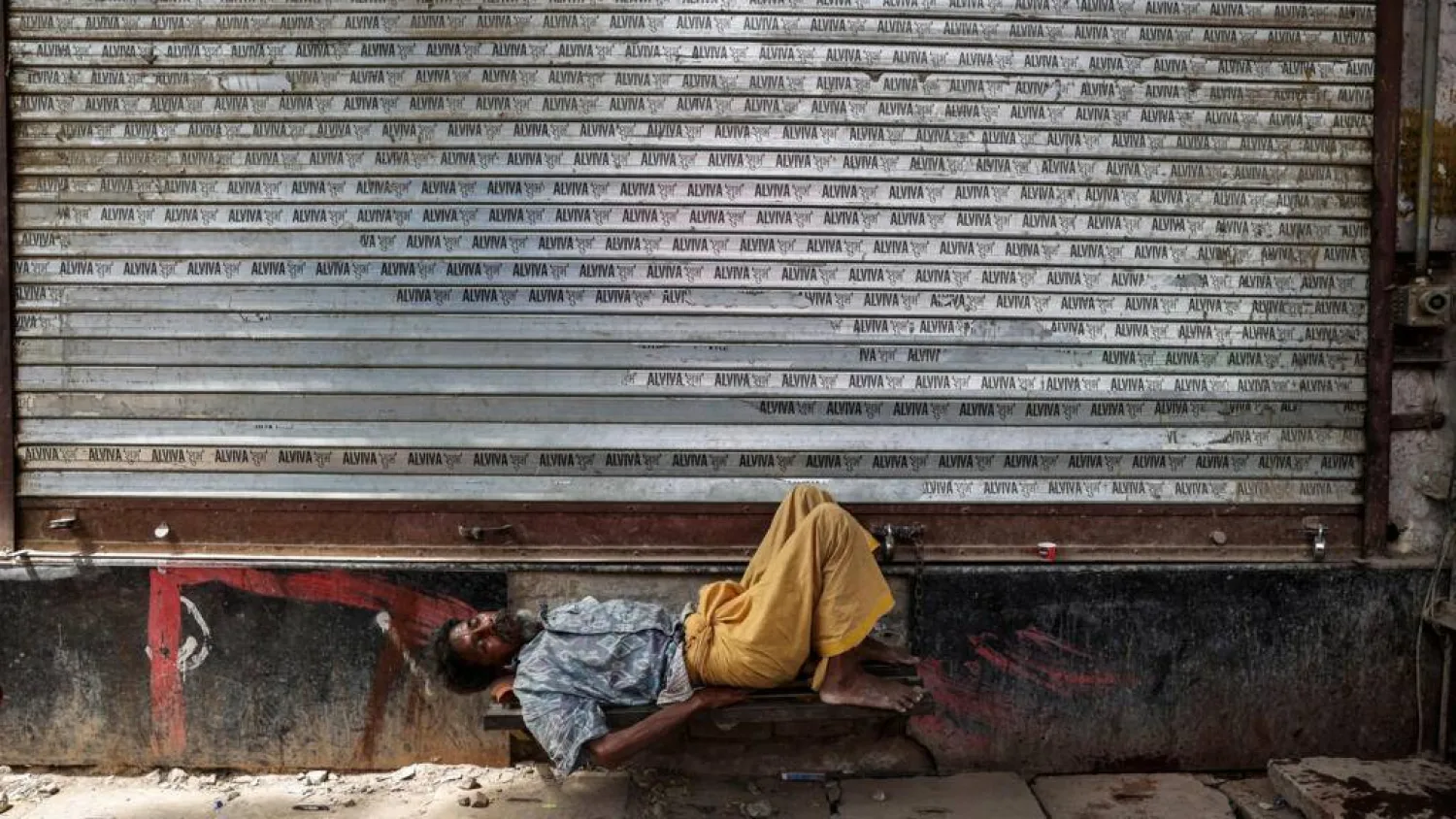 A man takes a nap in front of a closed shop on a hot summer day in Varanasi, in India's Uttar Pradesh, on May 23, 2026. Niharika KULKARNI / AFP
