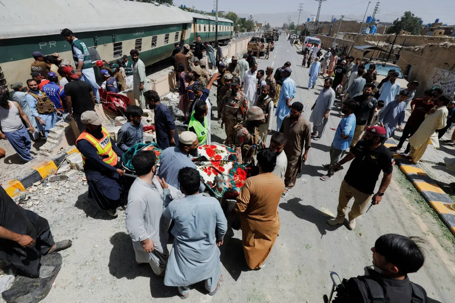 Pakistan’ın Ketta kentinde askerleri taşıyan bir trene düzenlenen bombalı saldırının ardından kurbanları arayan gönüllüler (AP)