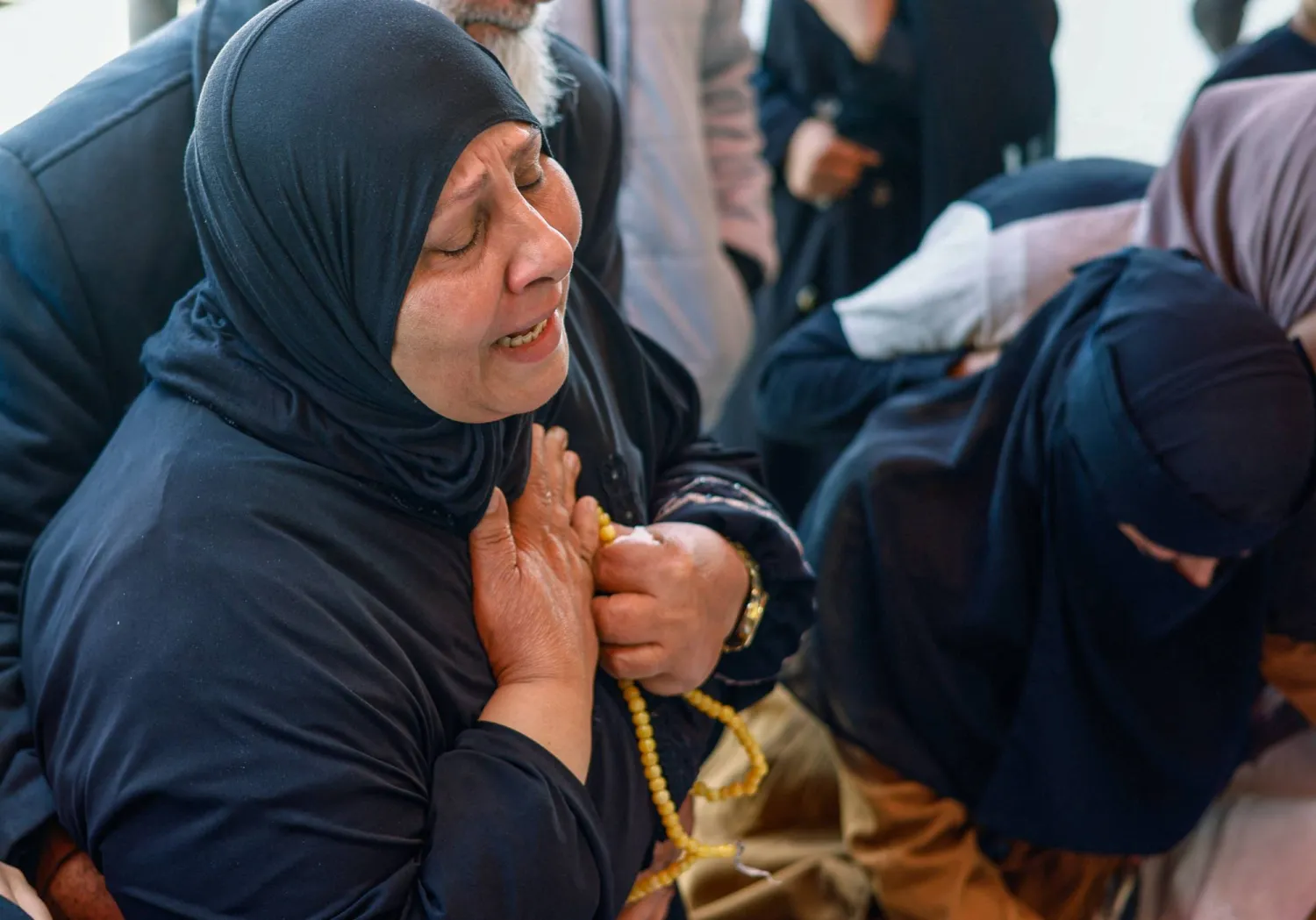 فلسطينية تنتحب خلال جنازة مواطنيها الذين قُتلوا في غارة إسرائيلية على منزل وسط قطاع غزة يوم الأحد (رويترز)