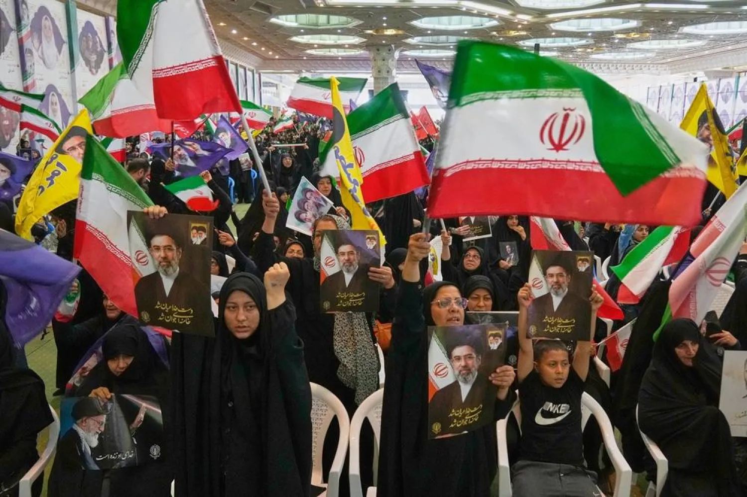 Government supporters hold Iranian flags and pictures of Iran's Supreme Leader, Mojtaba Khamenei, during a ceremony honoring the armed forces and those killed in the war with Israel and the US in Tehran, Iran, Sunday, May 24, 2026. (AP) 