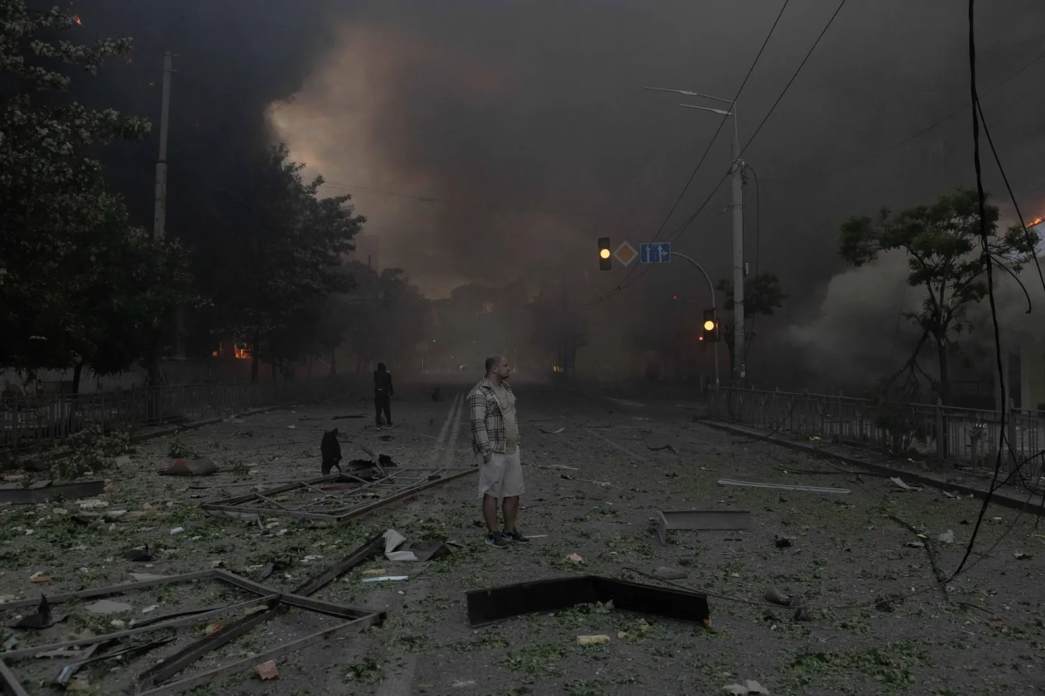 A man standing in smoke looks at heavily damaged buildings following Russian strikes in Kyiv on May 24, 2026, amid the Russian invasion of Ukraine. (AFP) 