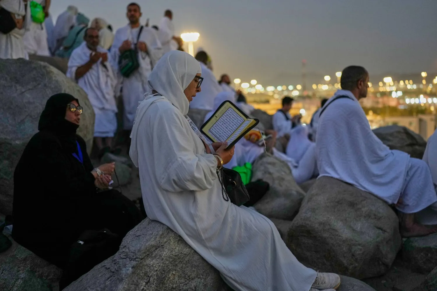 عدد من الحجاج يقرأون القرآن الكريم في صعيد عرفات (أ.ب)