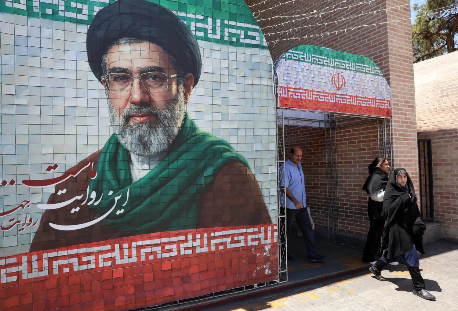 Iranians walk past a picture of Iranian supreme leader Mojtaba Khamenei in a street in Tehran, Iran, 18 May 2026. EPA/ABEDIN TAHERKENAREH