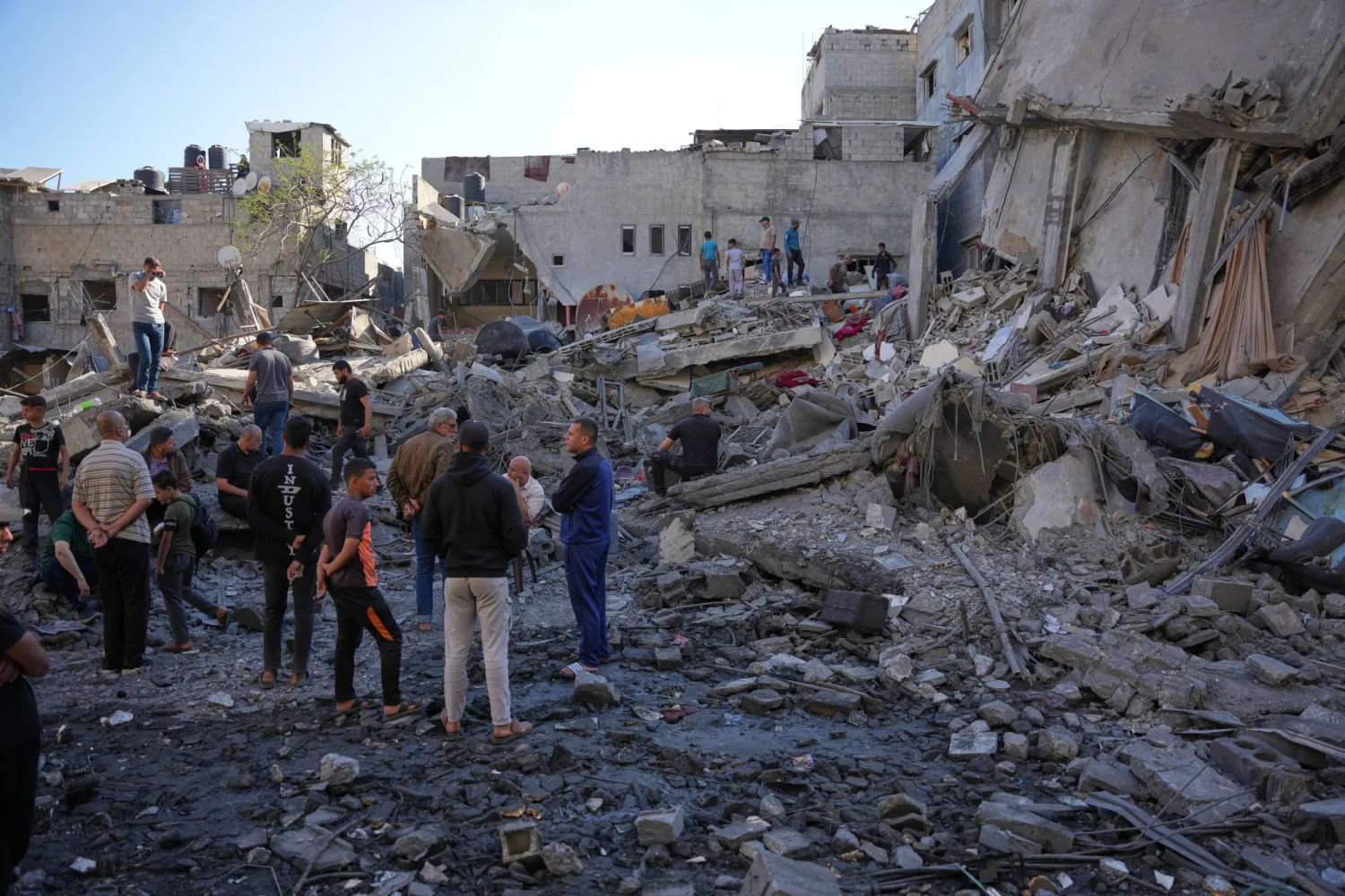 فلسطينيون يتفقدون أنقاض مبنى دمرته غارة جوية إسرائيلية في النصيرات - وسط قطاع غزة (أ.ب)