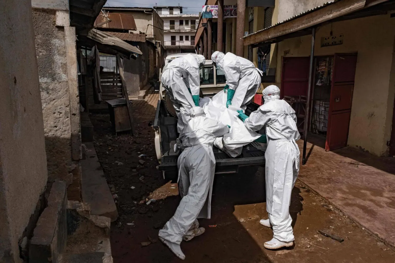 Uganda Kızılhaç Derneği çalışanları, Kampala'da Ebola şüphesi bulunan bir kişinin cesedini taşıyor (AFP)