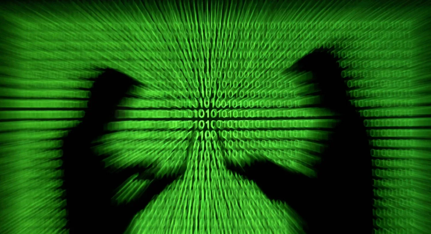 FILE PHOTO: Silhouettes of laptop users are seen next to a screen projection of binary code are seen in this picture illustration created on March 28, 2018.  REUTERS/Dado Ruvic/Illustration/File Photo