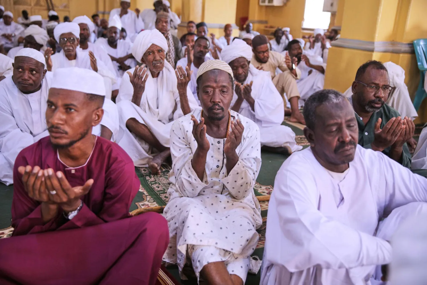 مصلون يستمعون لخطبة صلاة عيد الأضحى بأحد مساجد الخرطوم (أ.ب)
