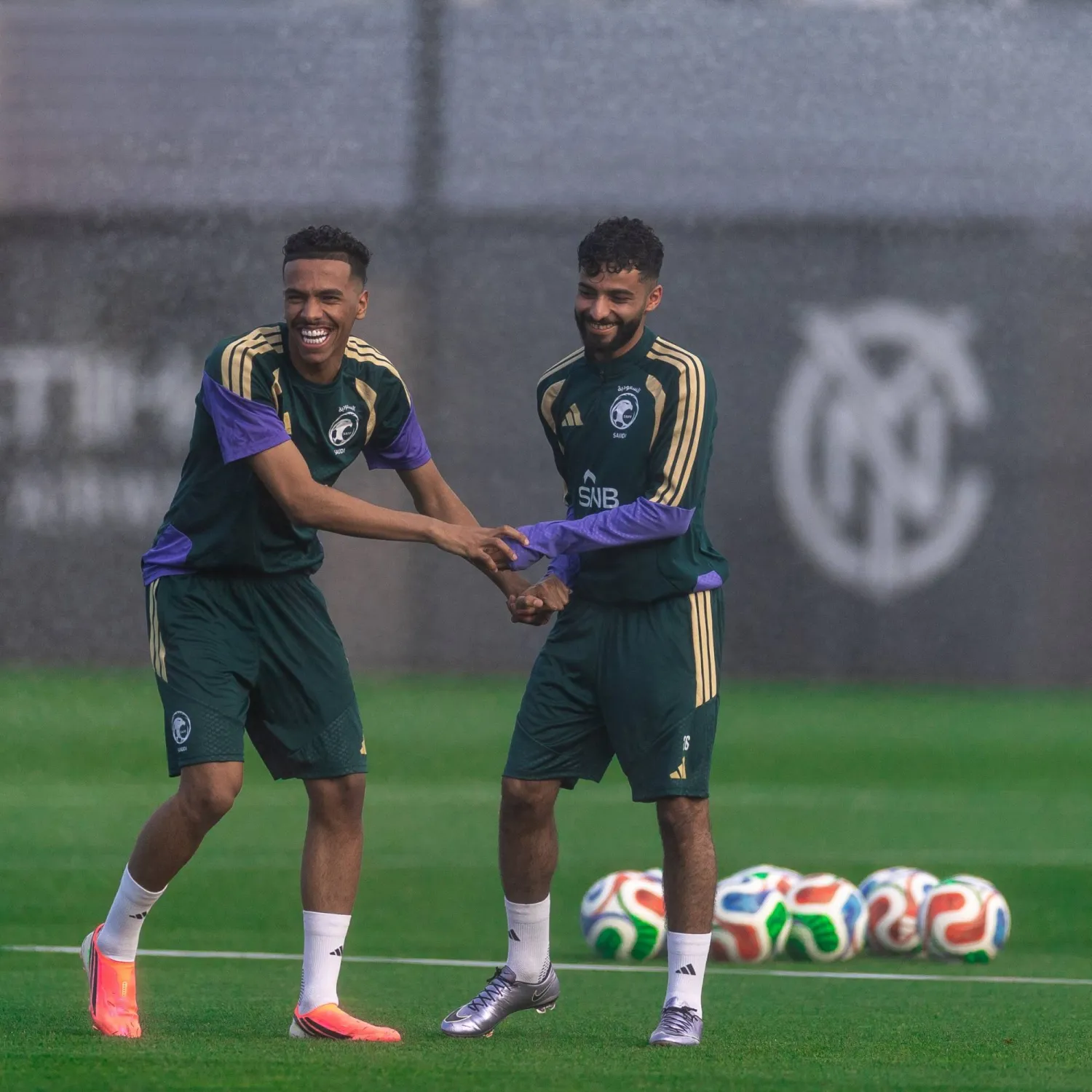 الجوير يمازح زميله أبو الشامات خلال المعسكر (المنتخب السعودي)