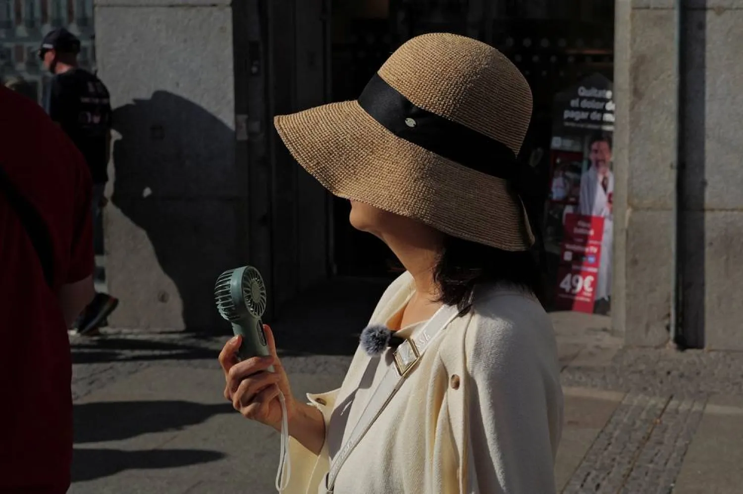  A woman uses a portable fan as she walks at Plaza Puerta del Sol during a spring heatwave in Madrid, Spain, May 27, 2026. (Reuters)