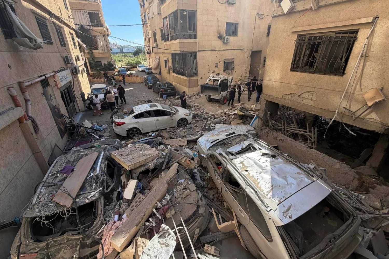 عمال إنقاذ وسكان محليون يتفقدون الأضرار التي لحقت بمبنى في أعقاب غارة جوية إسرائيلية بمنطقة الشويفات جنوب بيروت على مشارف الضاحية الجنوبية للعاصمة 28 مايو 2026 (أ.ف.ب)