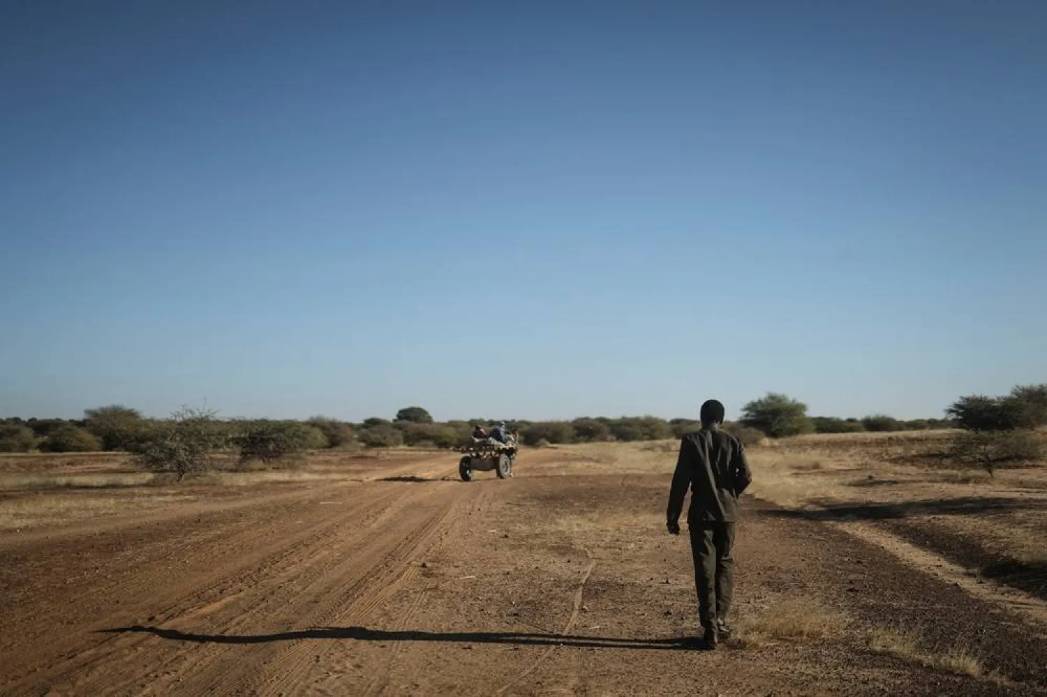 Ibrahim Ali, 26, a Sudanese refugee who fled Al-Fashir amid ongoing conflict in Sudan between the paramilitary Rapid Support Forces (RSF) and the Sudanese army, walks along a road towards his family's tents at the Tulum refugee camp, in Wadi Fira province, eastern Chad, November 29, 2025. (Reuters/Amr Abdallah Dalsh)