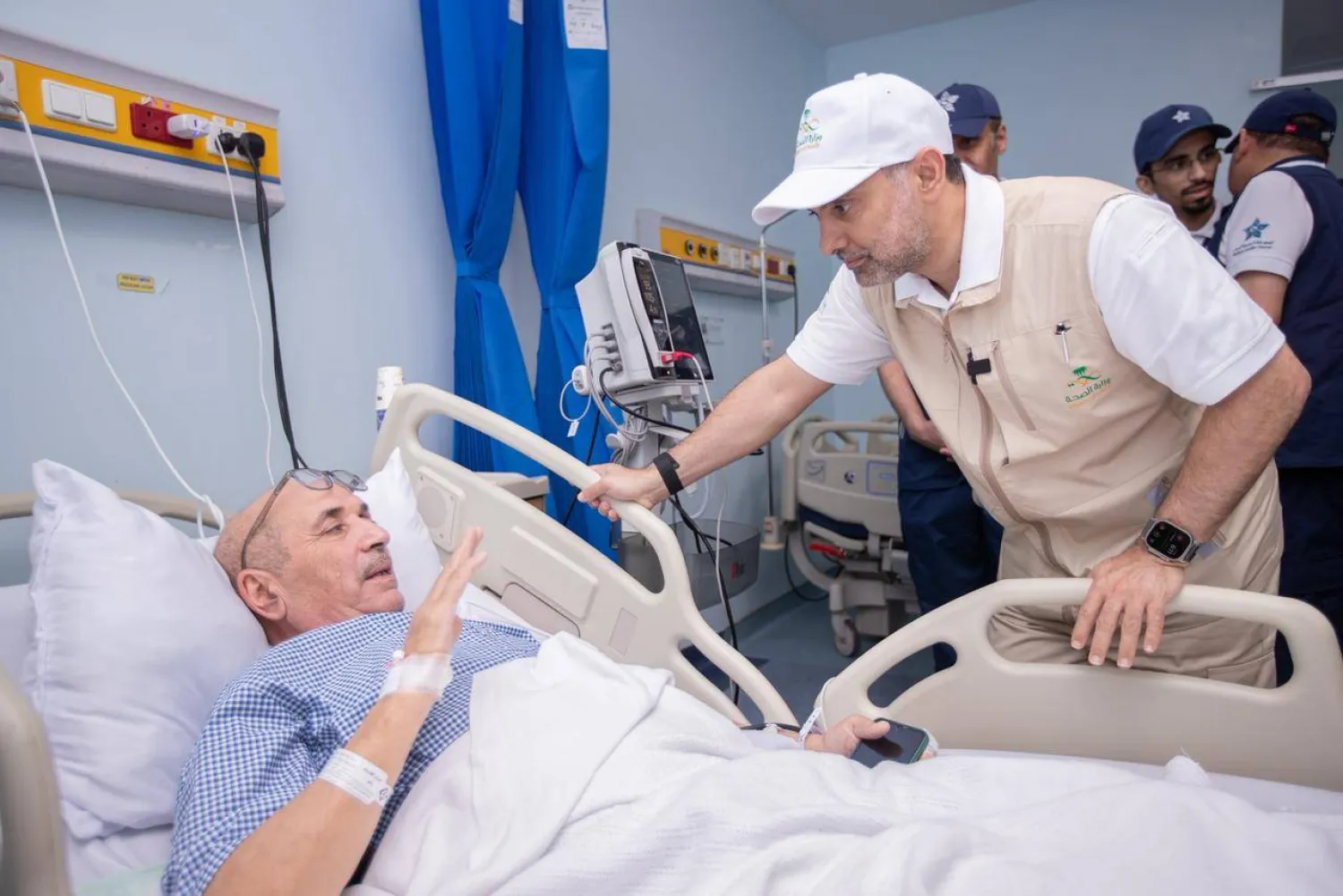فهد الجلاجل خلال اطمئنانه على صحة أحد الحجاج ضمن جولاته لمتابعة أعمال المستشفيات والمراكز الصحية في المشاعر المقدسة (الصحة السعودية)