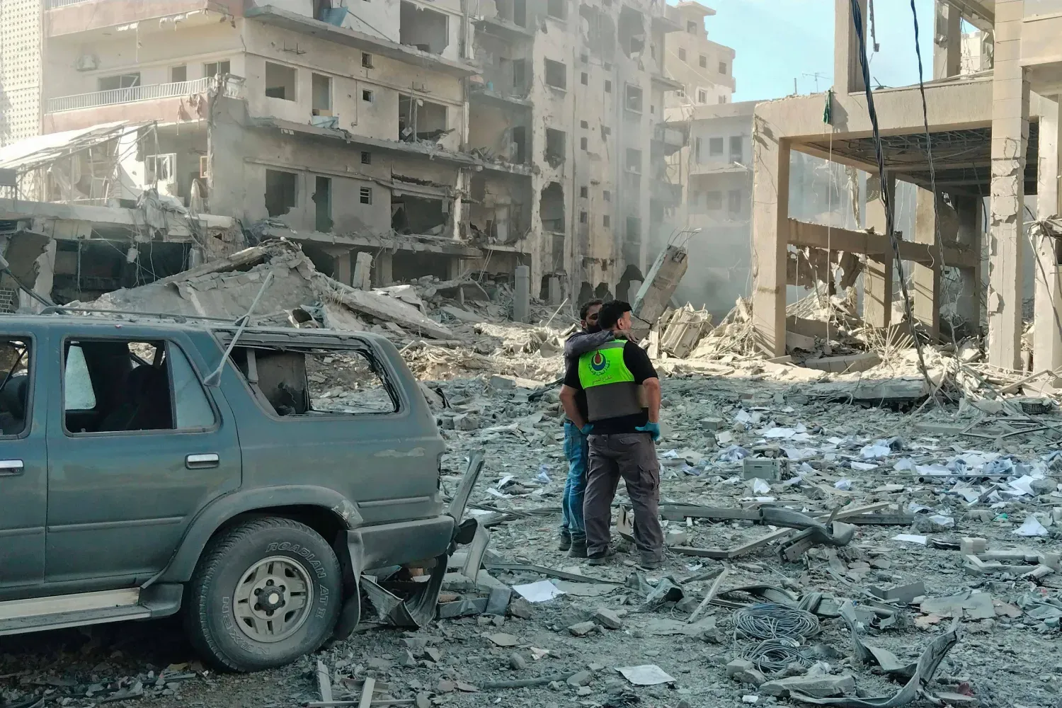 Lübnan Sivil Savunma güçleri, İsrail'in Sur şehrine düzenlediği hava saldırılarının yol açtığı hasarı inceliyor (AFP)
