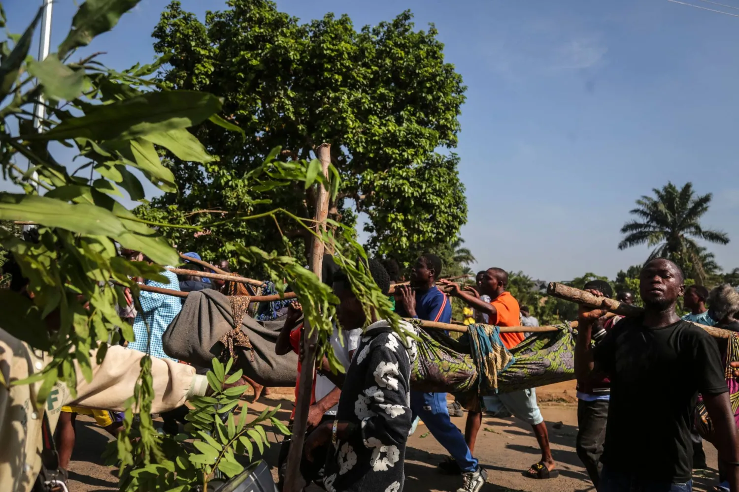 سكان في بيني يحملون جثث مدنيين أعدمهم مقاتلو تحالف القوى الديموقراطية في الكونغو (أ.ف.ب)