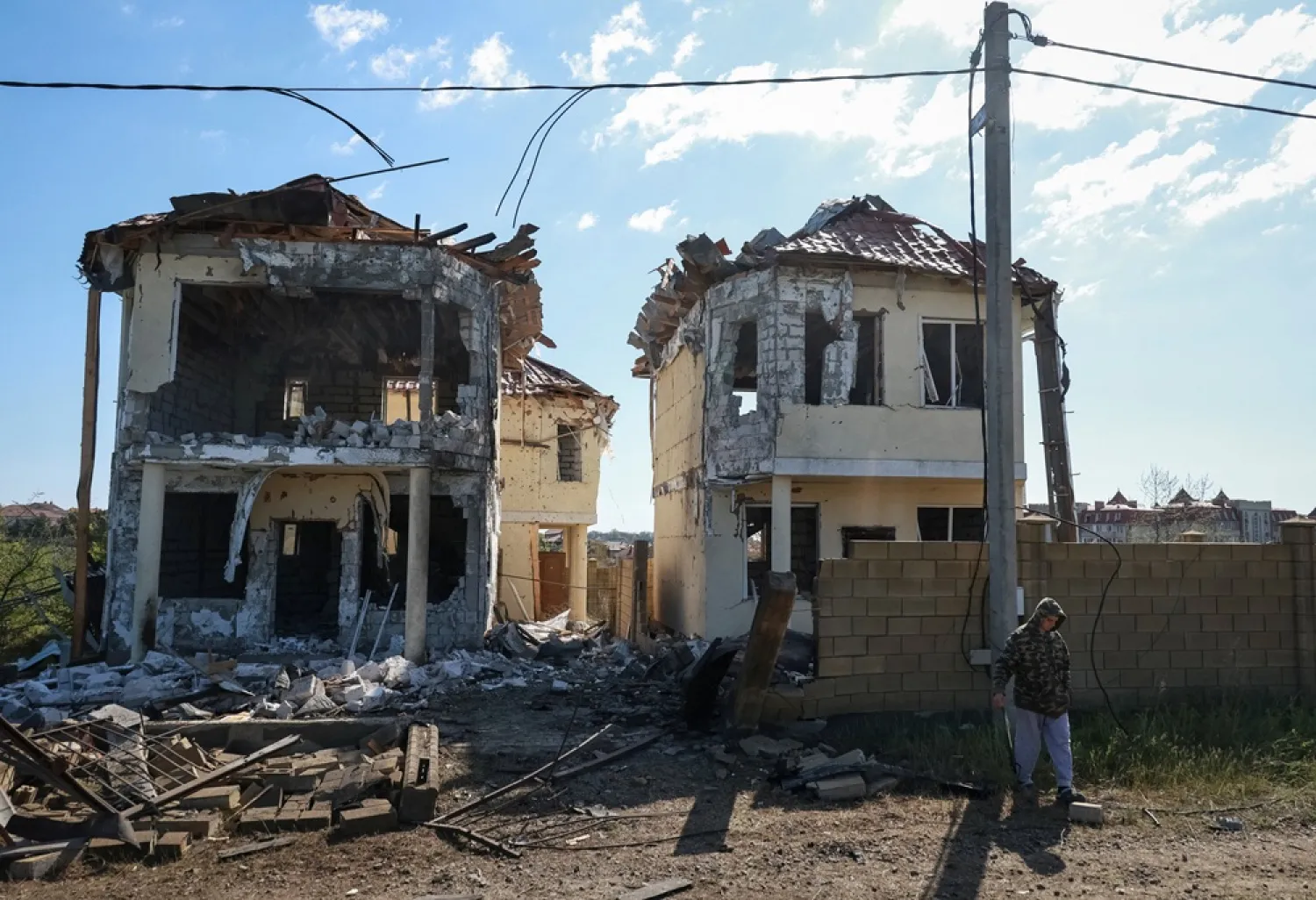 A resident stands near buildings damaged by a Russian drone strike, amid Russia's attack on Ukraine, near the city of Chornomorsk, Odesa region, Ukraine May 3, 2026. (Reuters) 