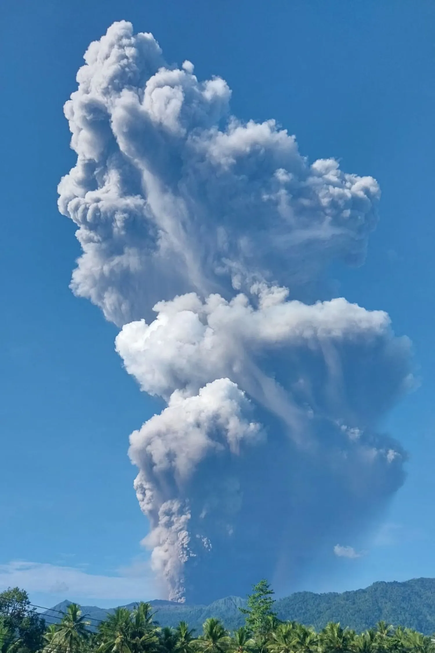 A handout picture taken and released by Indonesia’s Geological Agency on May 8, 2026, shows smoke rising from the eruption of Mount Dukono as seen from Tobelo, North Maluku. (Photo by Handout / Indonesia's Geological Agency / AFP) 