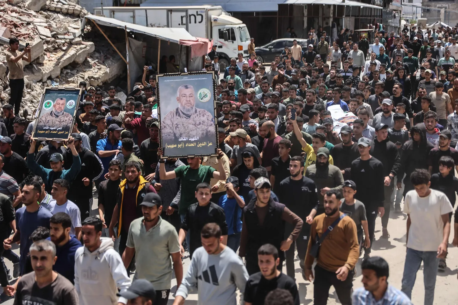 Mourners carry portraits of Ezzedine Al-Haddad, the slain chief of the Qassam Brigades -- the armed wing of Palestinian movement Hamas, who was killed in an overnight Israeli strike along with his daughter and wife, during their funeral in Gaza City on May 16, 2026. (AFP)