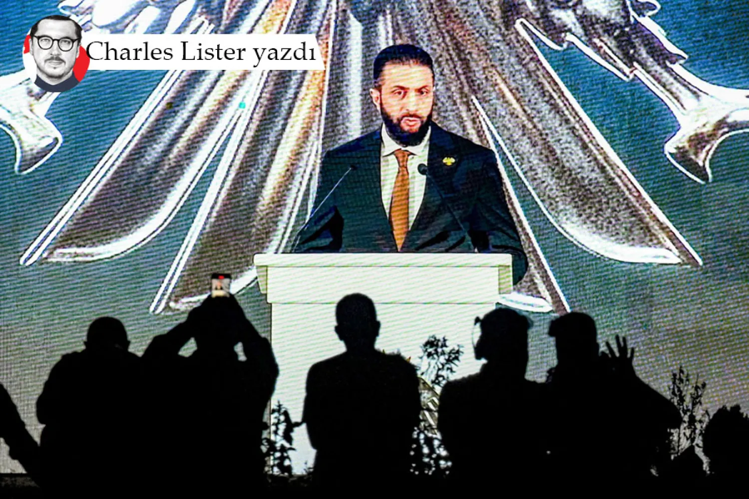 Şam'a bakan Kasiyun Dağı'ndaki Meçhul Asker Anıtı yakınlarında, yeni ulusal amblemin tanıtımı sırasında, Suriye Cumhurbaşkanı Ahmed eş-Şara'nın konuşmasını dev bir ekranda izleyen insanlar, 3 Temmuz 2025 (AFP)