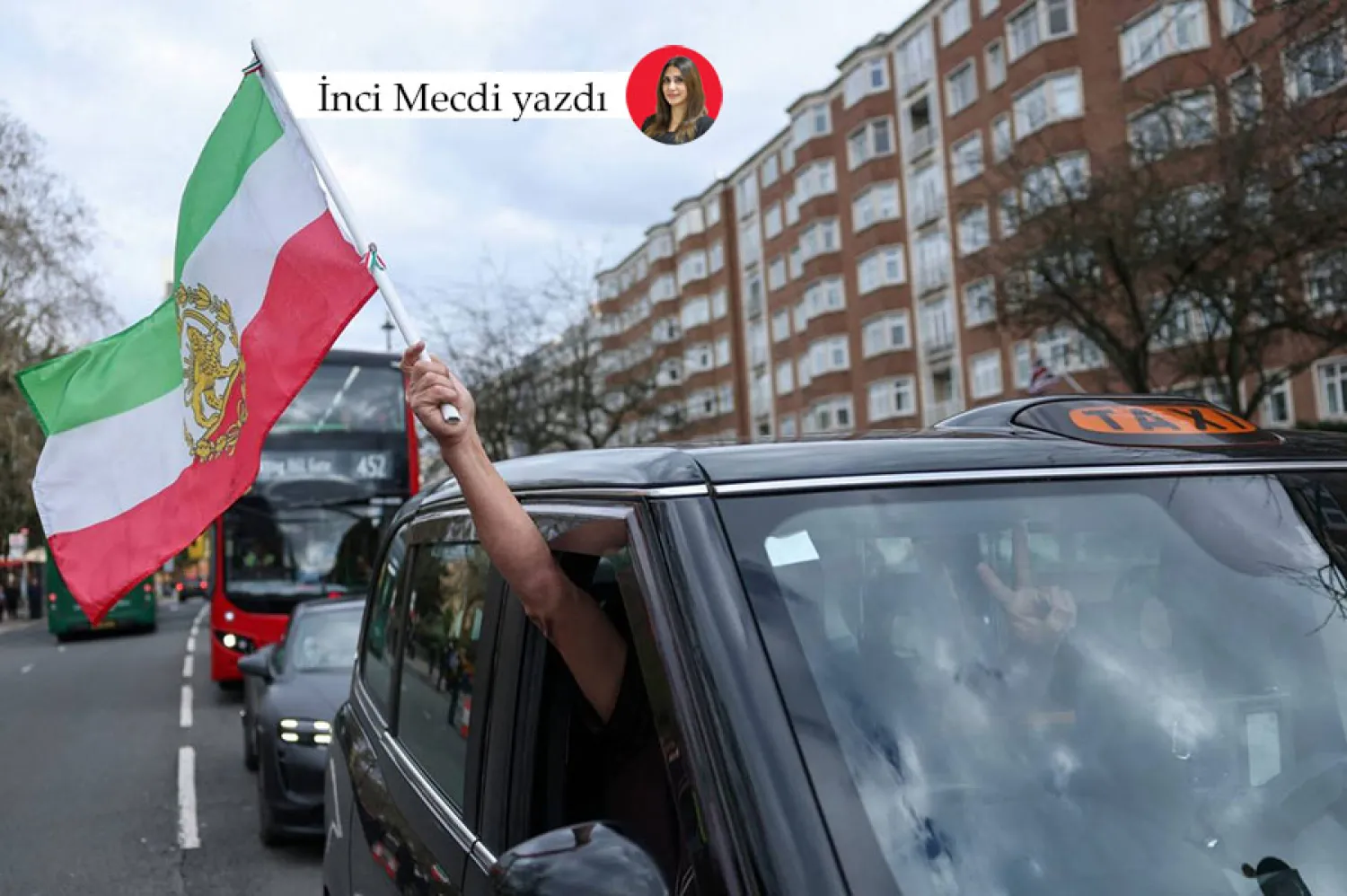 Londra'daki İran Büyükelçiliği önündeki rejim karşıtı bir gösteri sırasında bir İranlı protestocu üstünde “Aslan ve Güneş” olan İran bayrağını taşıyor (Reuters)