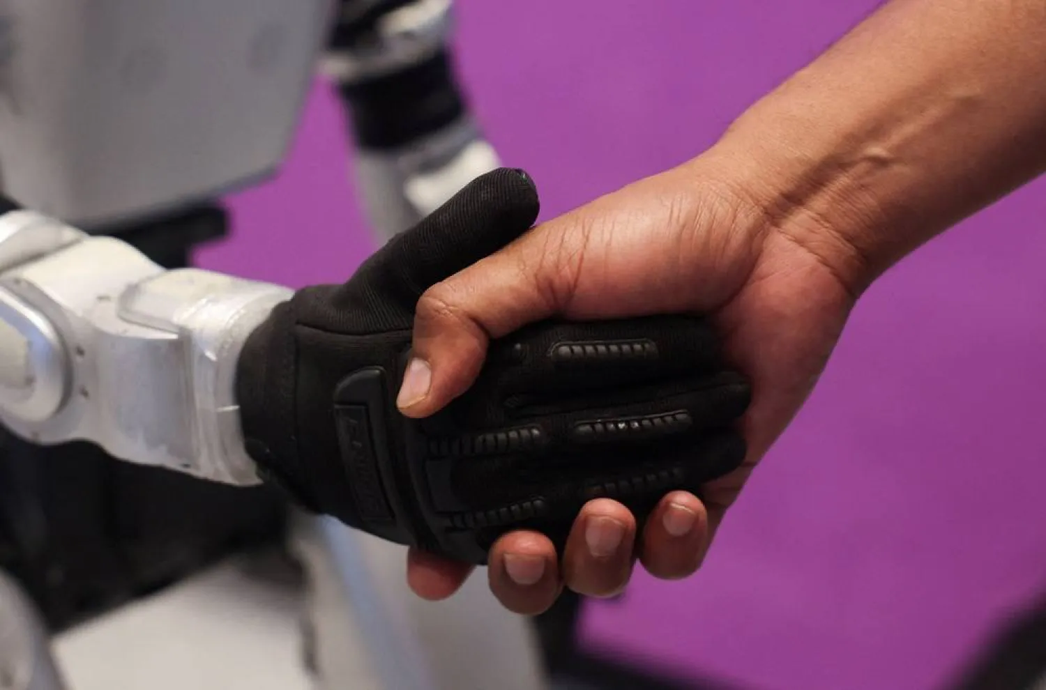 A man shakes the hand of a Chinese G1 humanoid robot made by Unitree Robotics at a conference in Mumbai, India, May 22, 2026. (Reuters)