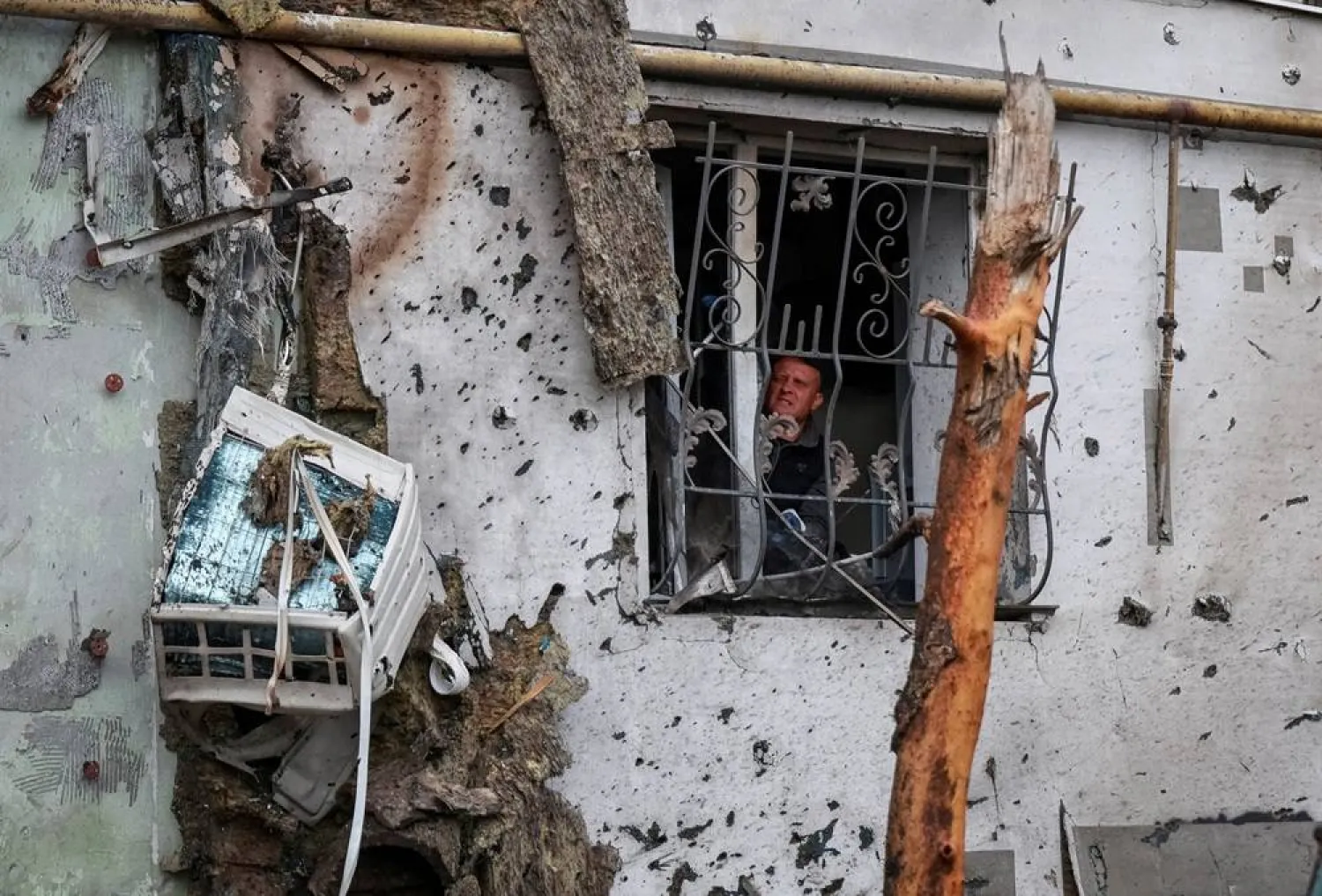 A resident removes broken glass from a window of an apartment building damaged by a Russian drone strike, amid Russia's attack on Ukraine, in Odesa, Ukraine June 1, 2026. (Reuters) 