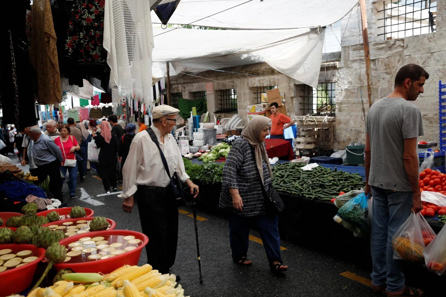 أشخاص يتسوّقون بإحدى الأسواق في إسطنبول (رويترز)