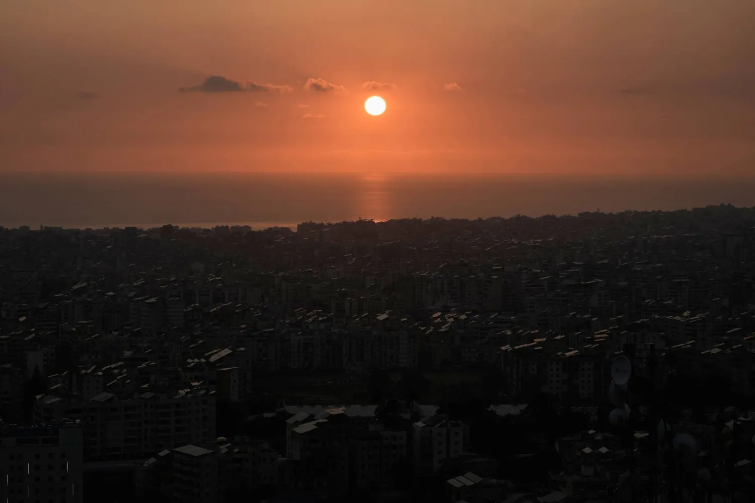 الشمس تغرب فوق الضاحية الجنوبية لبيروت في أعقاب تهديد إسرائيلي بضرب المنطقة (أ.ب)