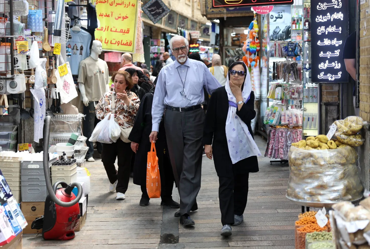 الناس يتسوقون في سوق بطهران (إ.ب.أ)