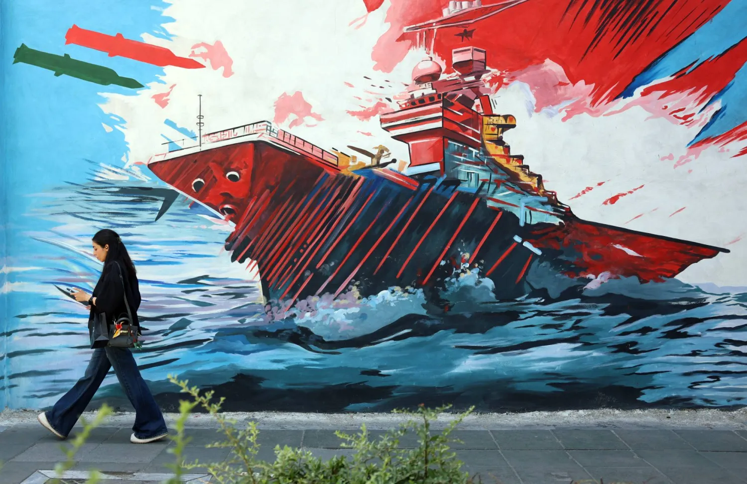 An Iranian woman walks next to an anti-US and Israeli mural in Tehran, Iran, 03 June 2026. EPA/ABEDIN TAHERKENAREH