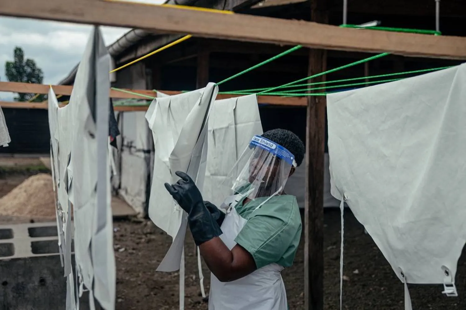A staff member hangs up protective equipment to dry after washing them at the Ebola Treatment Center (ETC) in Munigi on June 2, 2026. (AFP)