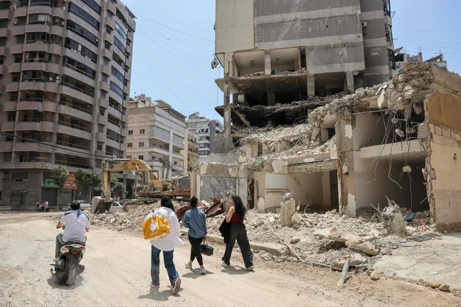 مواطنون في الضاحية الجنوبية حيث الدمار يعم المكان نتيجة القصف الإسرائيلي الذي استهدف المنطقة (أ.ف.ب)