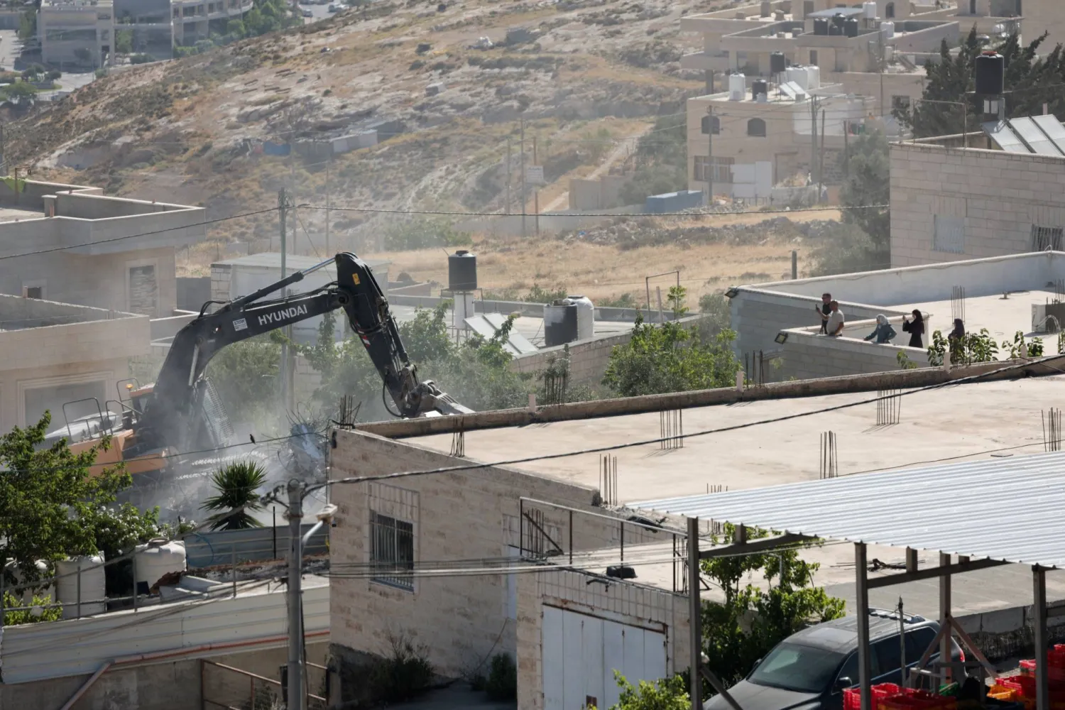 حفارة إسرائيلية تهدم مبنى للفلسطينيين في الضفة الغربية (رويترز)