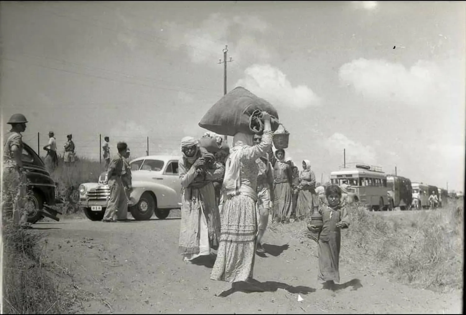 فلسطينيون معظمهم من النساء والأطفال في طريقهم للخروج من منازلهم بقرية الطنطورة في مايو 1948 بعد جرائم «تطهير عرقي» ارتكبتها عصابات صهيونية بحق رجال القرية (موقع فلسطين في الذاكرة)
