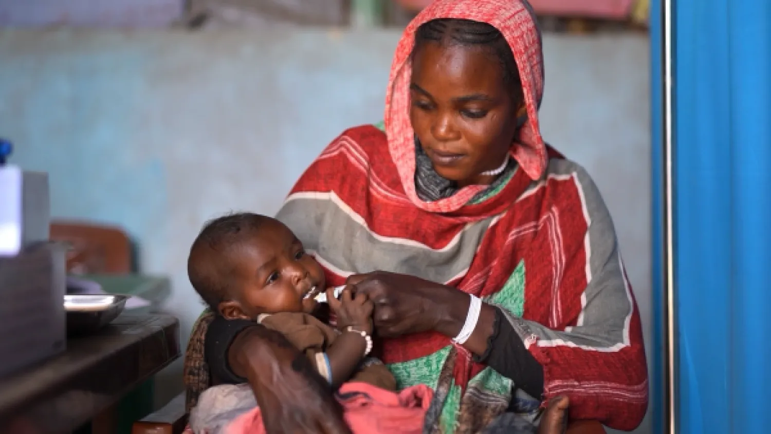مواطنة سودانية تحاول إسكات جوع طفلها الرضيع (يونيسف)