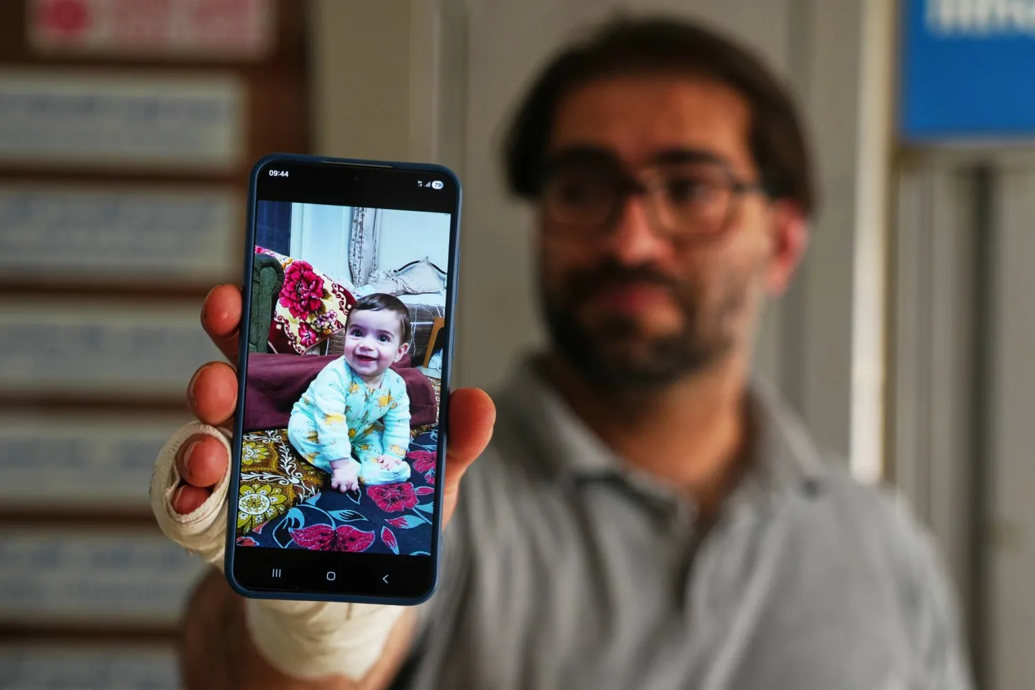 Fahd Abu Heikal, 41 displays a mobile photo of his seven month old Palestinian baby boy Sam, who was killed on Friday when Israeli soldiers fired at the vehicle carrying him and his parents, in Tel Rumeida, at a hospital in the West Bank city of Hebron Saturday, June 6, 2026. (AP Photo/Mahmoud Illean)