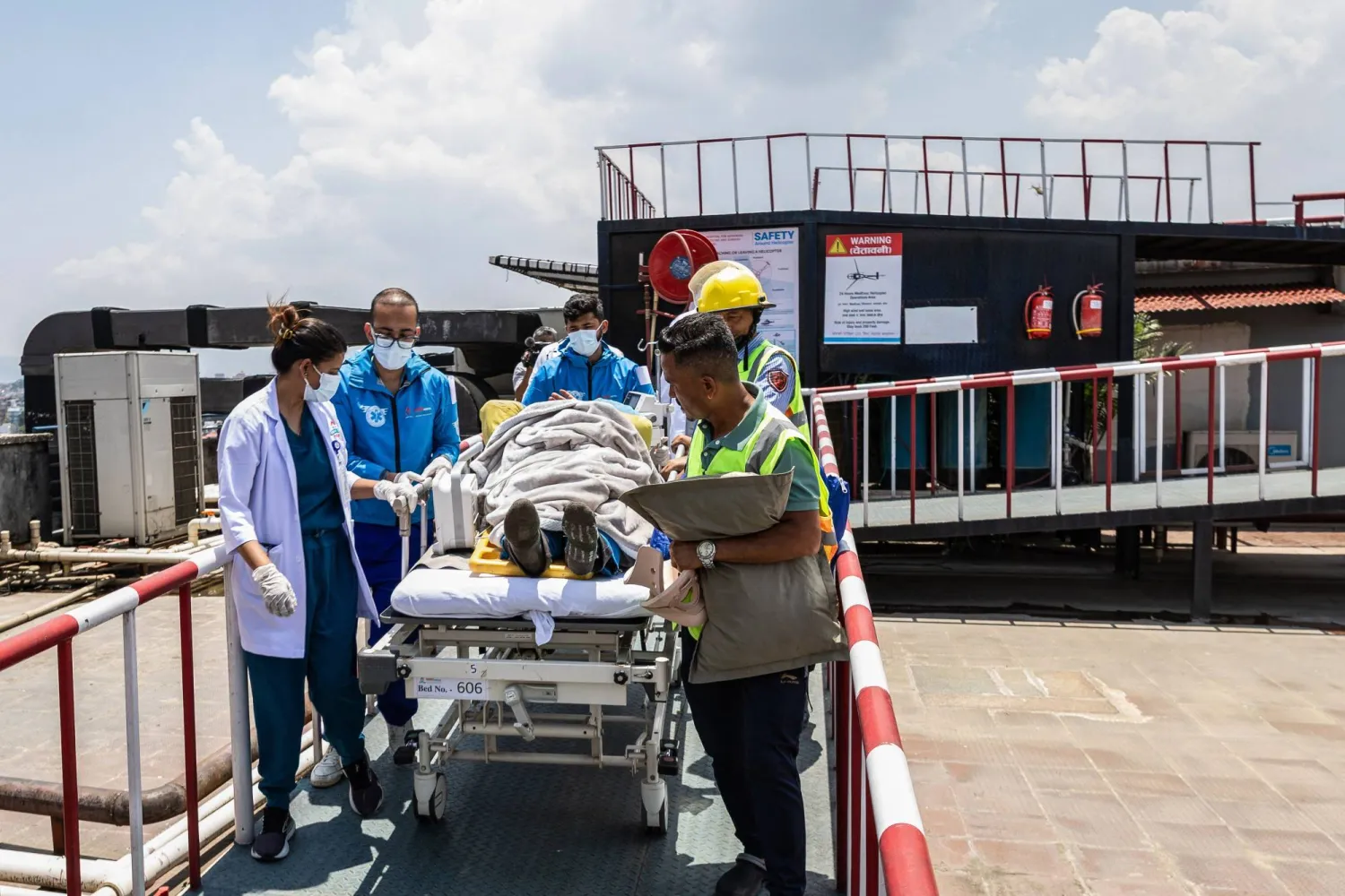 Medics and rescuers carry mountaineer Dawa Sherpa upon his arrival at the HAMS Hospital in Kathmandu on June 4, 2026. (Photo by PRABIN RANABHAT / AFP)