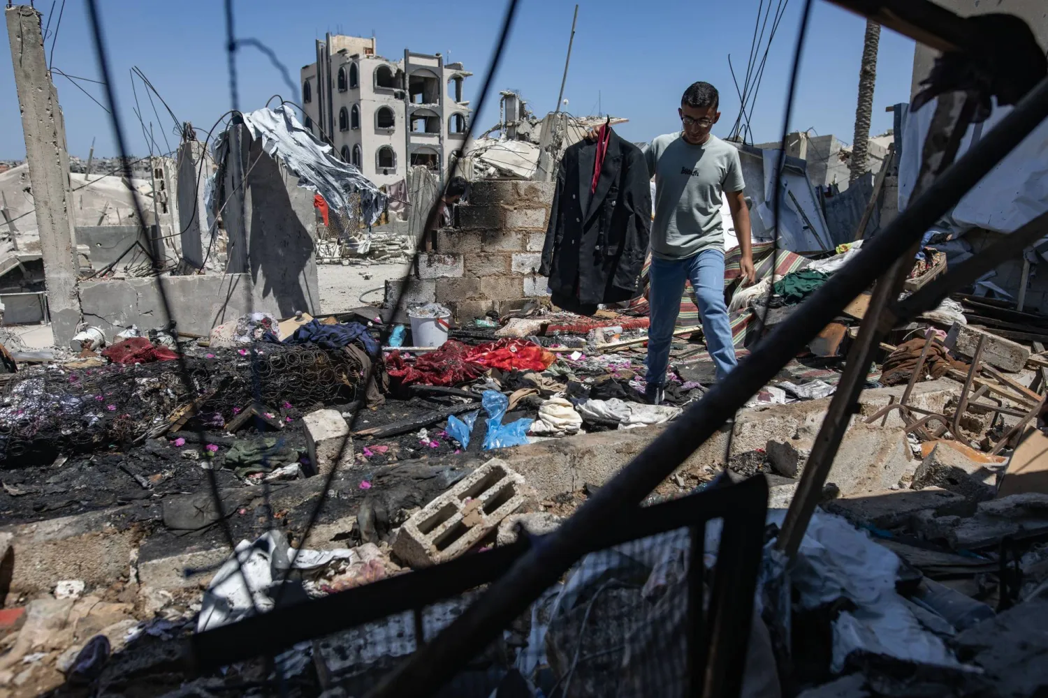 فلسطيني يحمل جاكيت الشاب مهند فروانة الذي قتلته غارة إسرائيلية بينما كان يتجهز لحفل زفافه ظهر اليوم في خان يونس جنوب قطاع غزة (إ.ب.أ)