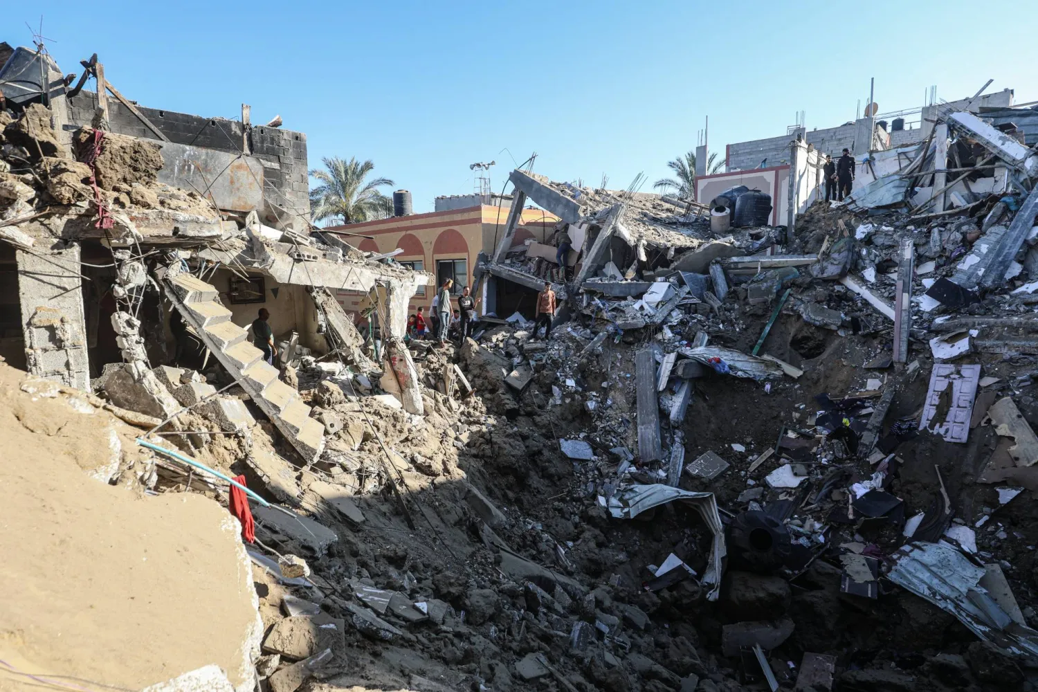 فلسطينيون يعاينون ركام مبنى استهدفته غارة جوية إسرائيلية في دير البلح وسط قطاع غزة 29 مايو 2026 (د.ب.أ)