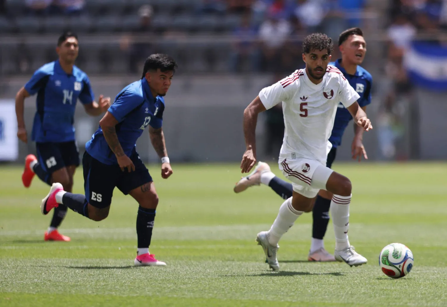 جاسم جابر لاعب منتخب قطر يحاول لعب الكرة تحت ضغط مارسيلو دياز لاعب السلفادور (أ.ف.ب)