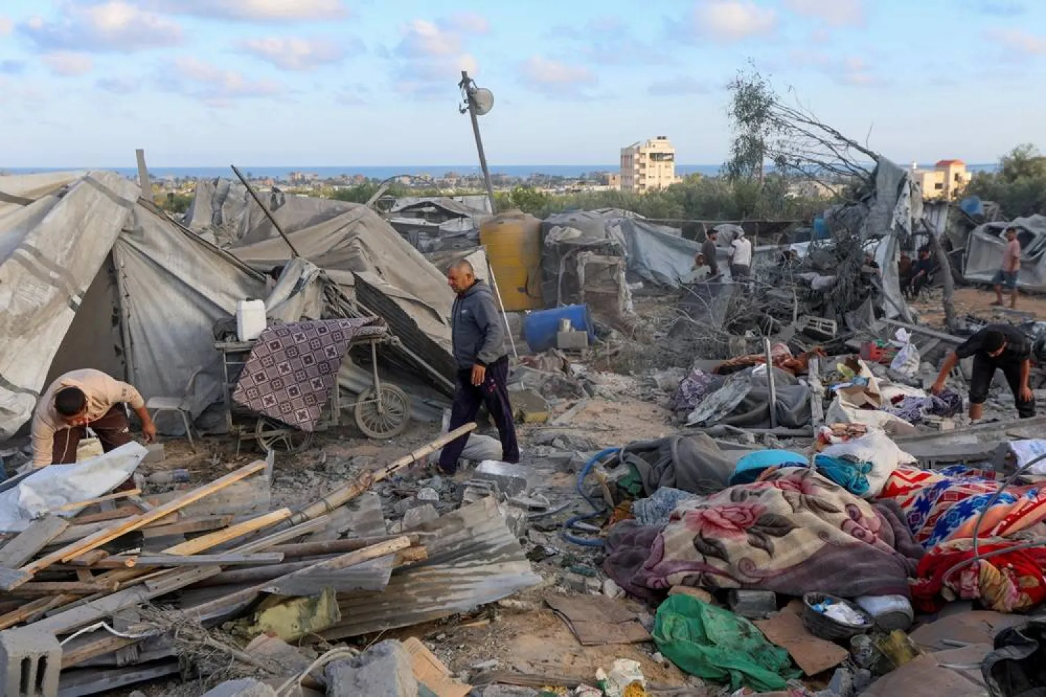  Palestinians inspect the damage to a tent camp sheltering displaced people in the aftermath of an Israeli strike on a nearby house whose residents were warned to evacuate before the attack, in Khan Younis in the southern Gaza Strip June 7, 2026. (Reuters)