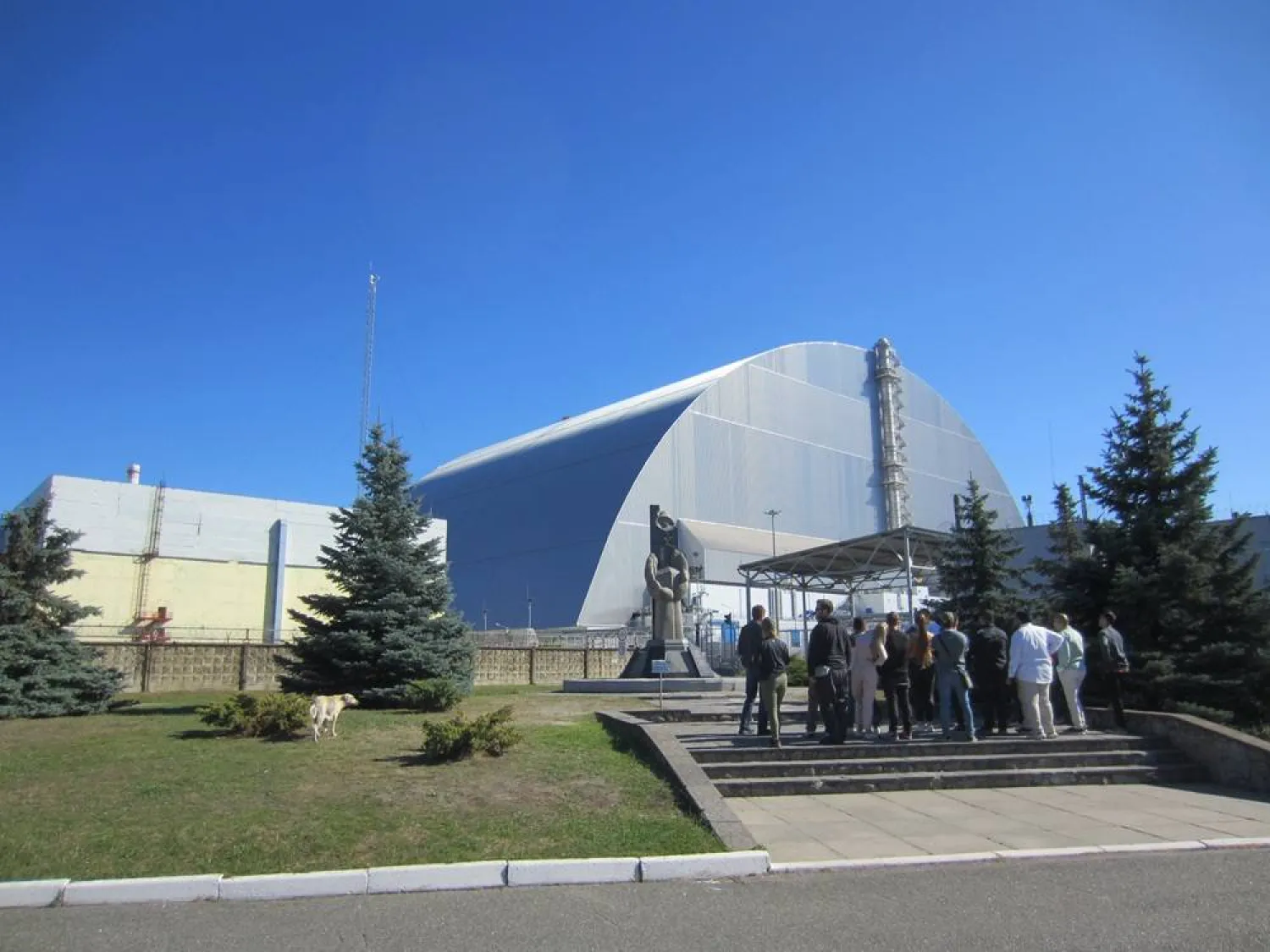 15 September 2021, Ukraine, Chornobyl: A group of tourists stand at the memorial in front of unit four of the Chornobyl nuclear power plant in Ukraine, which exploded in 1986. (dpa) 