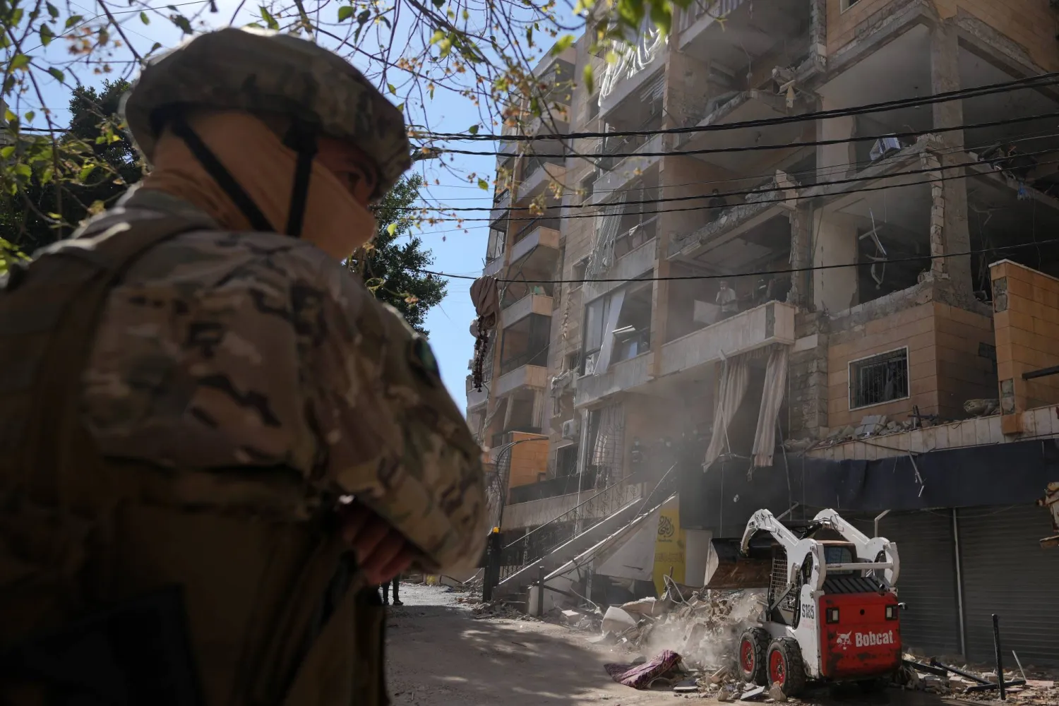 عسكري في الجيش اللبناني يقف في الموقع الذي أصابت فيه غارة جوية إسرائيلية مبنى في الضاحية الجنوبية لبيروت (أ.ب)