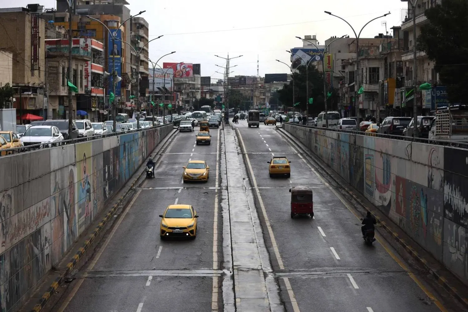  Vehicles enter and exit an underpass road during rainfall in Baghdad on March 15, 2026. (AFP) 